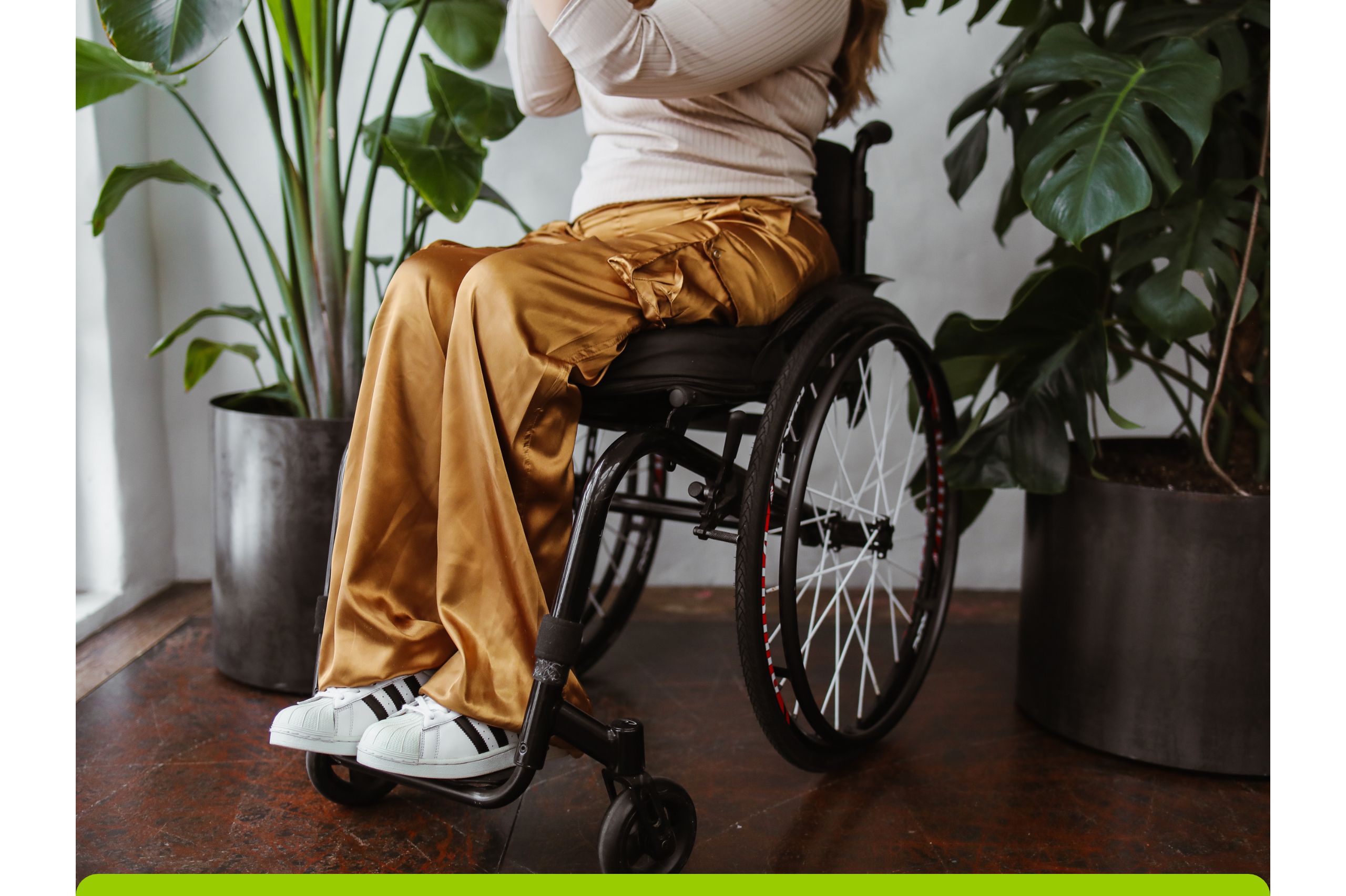 Foto: [Frau im Rollstuhl mit modischer goldener Hose].