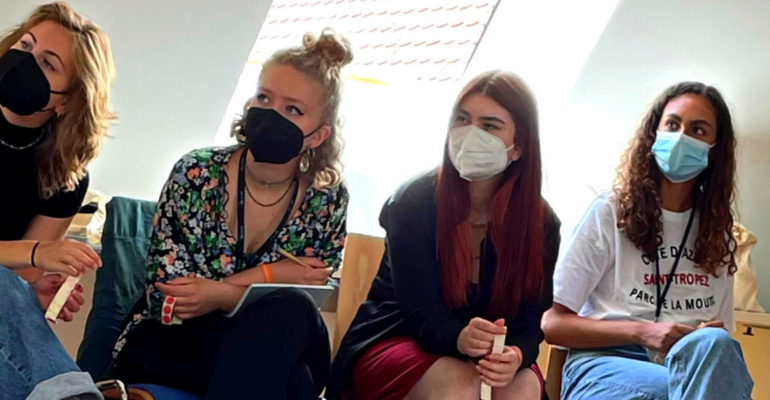Teilnehmer*innen der youcoN 2022 sitzen mit medizinischen Masken im Workshopraum