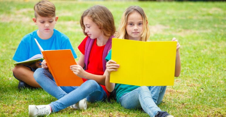 Kinder lesen im Park