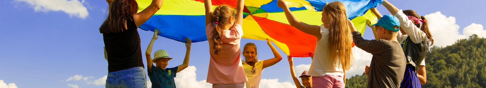 Förderfonds Persönlichkeitsentwicklung - Kinder interagieren mit farbigem Tuch